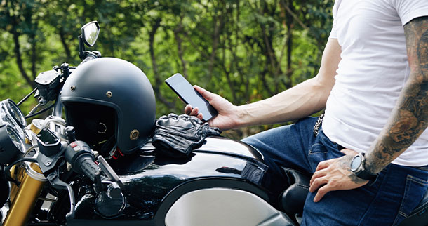 man on motorcycle holding phone