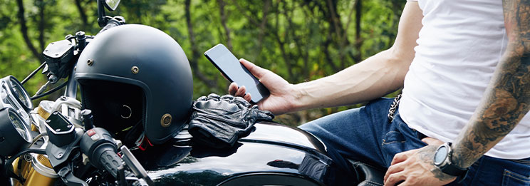 man on motorcycle holding phone